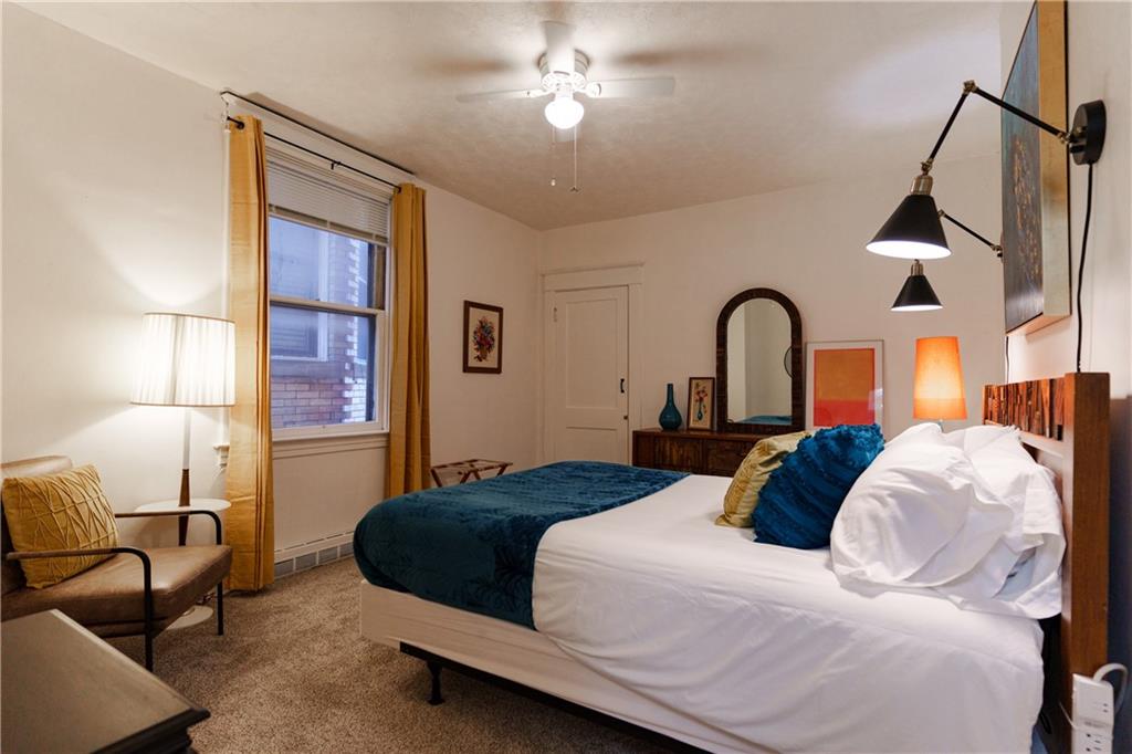 17 Bailey Avenue Pittsburgh, PA 15211 - Photo 20 of 22 a bedroom with a large bed and a chandelier