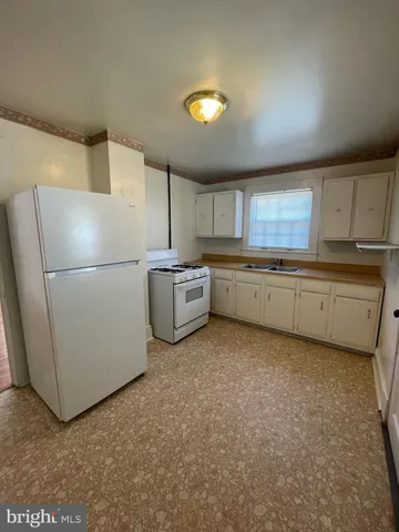 a kitchen with stainless steel appliances granite countertop a refrigerator a stove a sink and a more cabinets