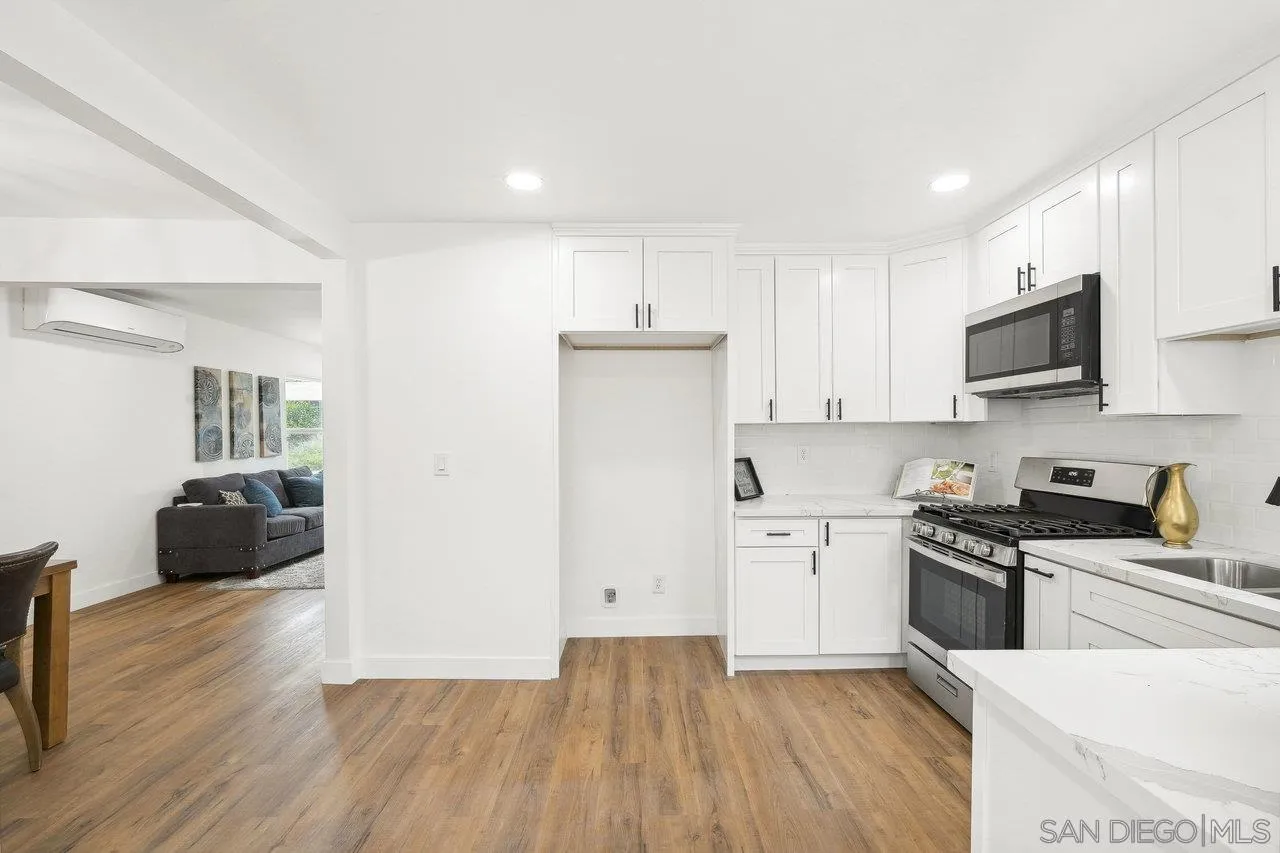 4741 Maple Avenue La Mesa, CA 91942 - Photo 15 of 34 a kitchen with granite countertop a refrigerator oven a sink dishwasher and white cabinets with wooden floor