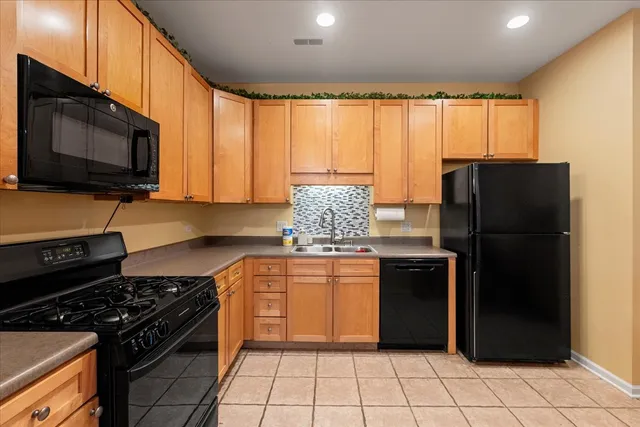 a kitchen with stainless steel appliances granite countertop a refrigerator stove top oven and sink