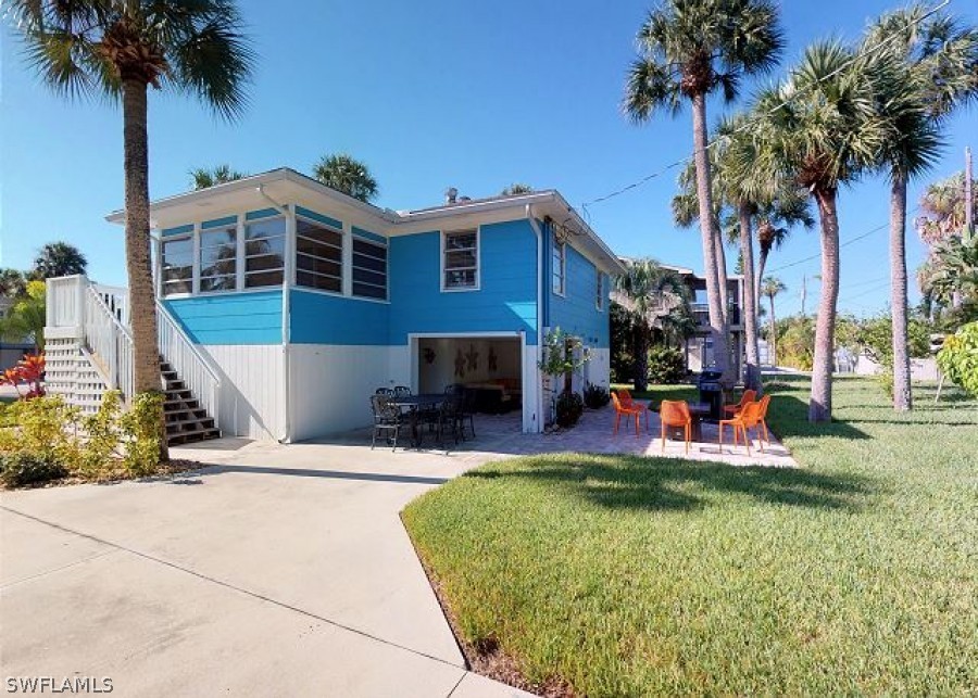 a front view of a house with swimming pool and porch with furniture