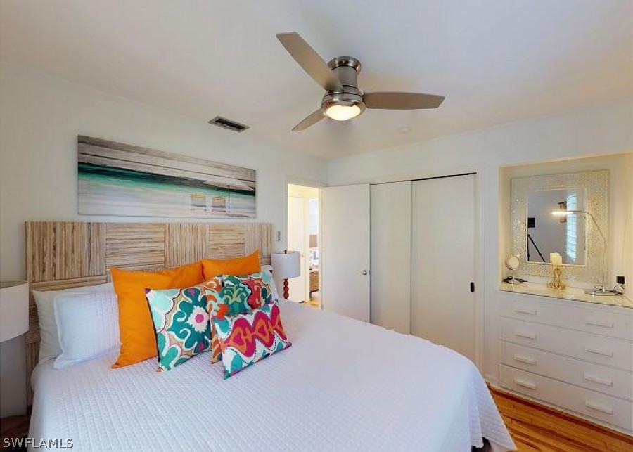 151 Mandalay Road Fort Myers Beach, FL 33931 - Photo 18 of 32 a bedroom with a bed and ceiling fan