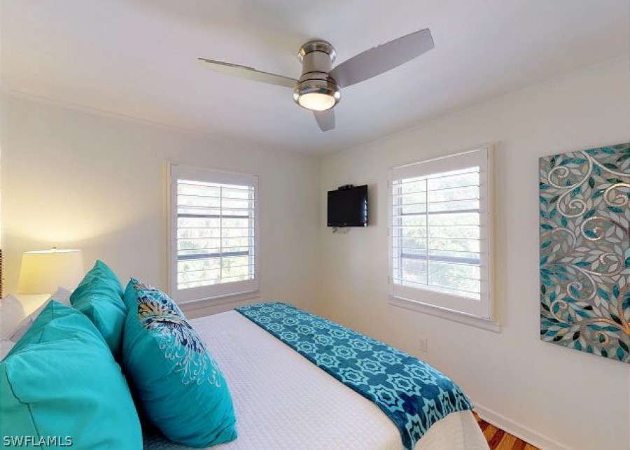151 Mandalay Road Fort Myers Beach, FL 33931 - Photo 21 of 32 a bed sitting in a bedroom next to a window