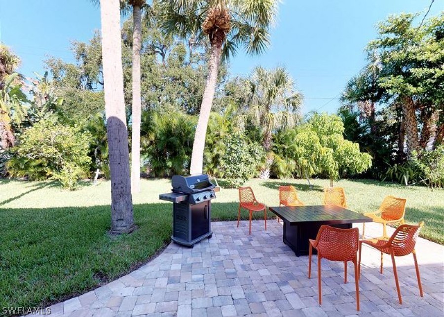 151 Mandalay Road Fort Myers Beach, FL 33931 - Photo 26 of 32 a view of yard with seating space and trees in the background