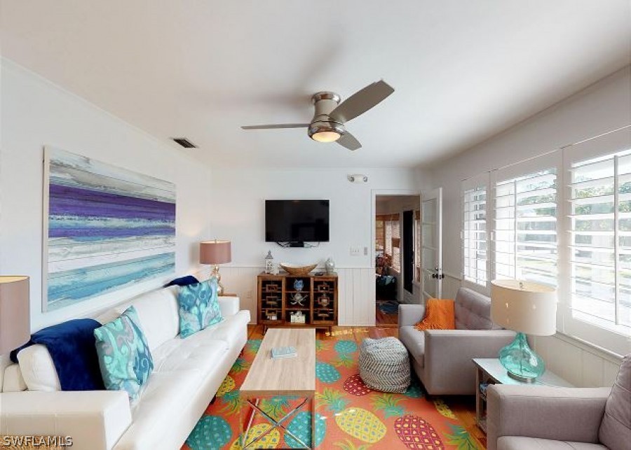 151 Mandalay Road Fort Myers Beach, FL 33931 - Photo 10 of 32 a living room with furniture flat screen tv and a large window
