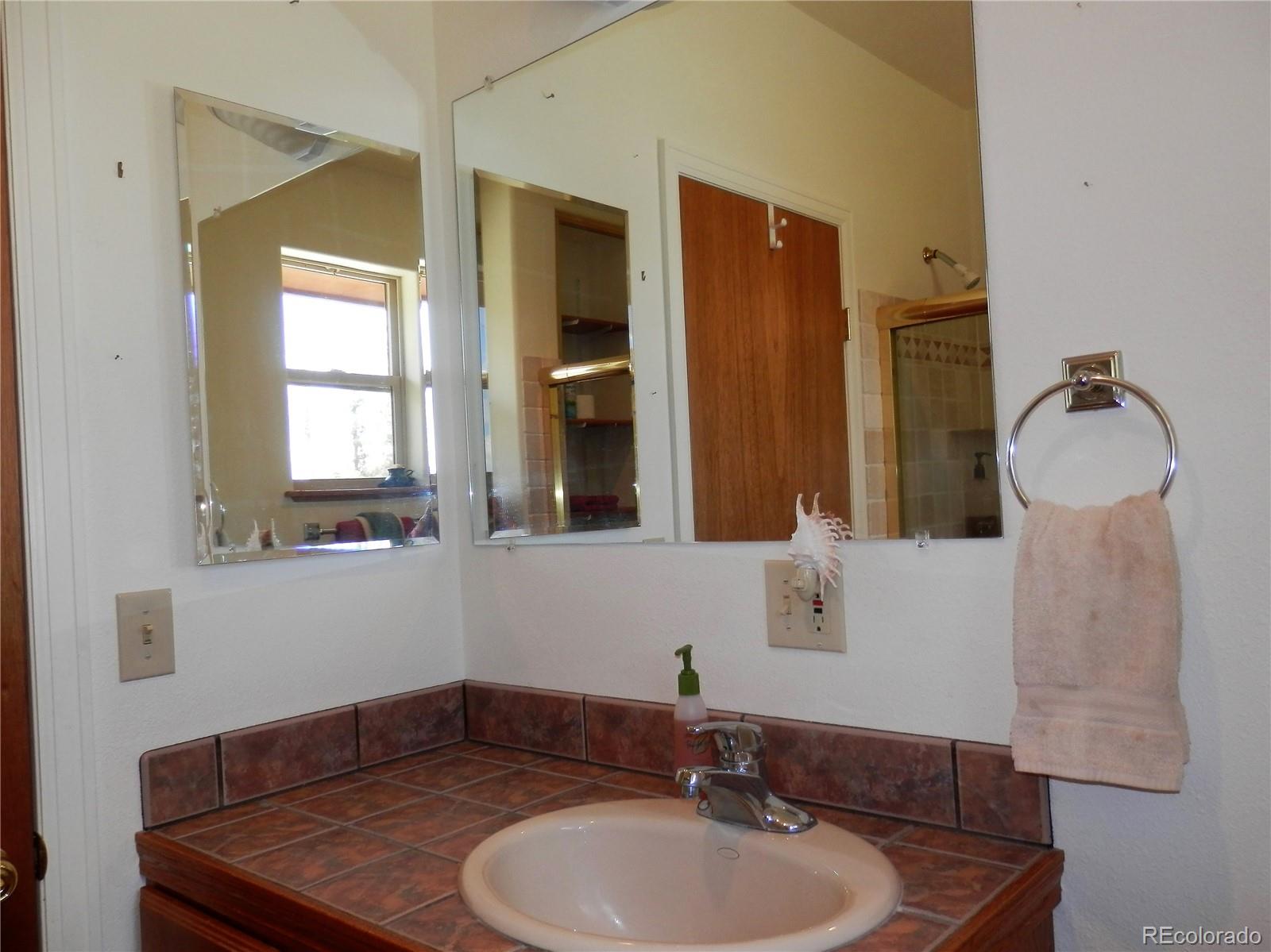 4469 Ranch Road Hartsel, CO 80449 - Photo 17 of 40 a bathroom with a sink vanity and mirror