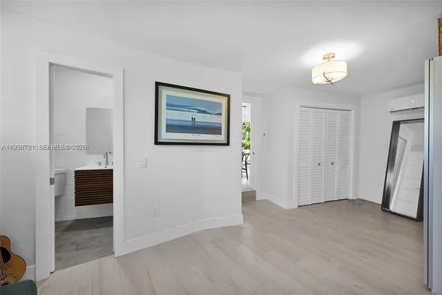 an empty room with wooden floor and a ceiling fan