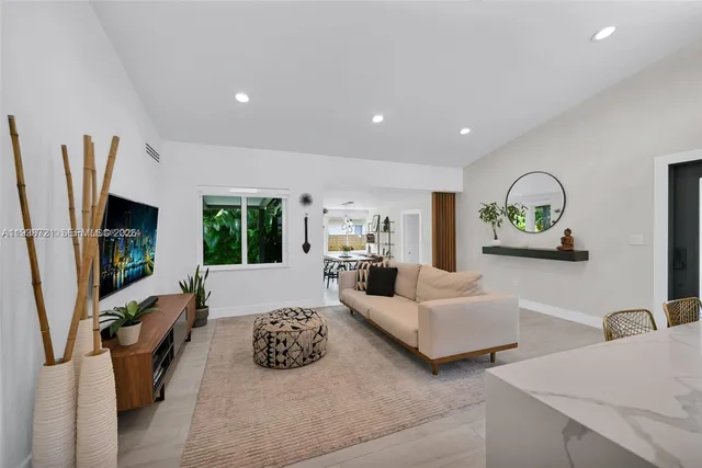 a living room with furniture a flat screen tv and a large window