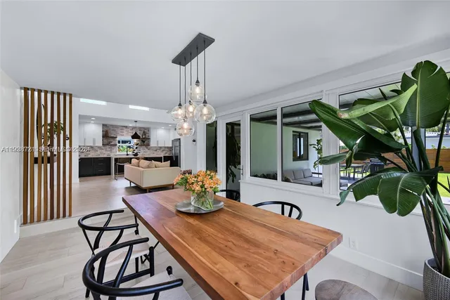 a dining room with furniture a potted plant and wooden floor