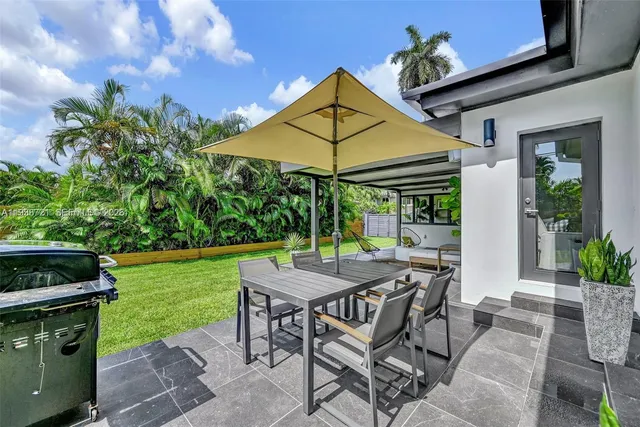 a view of patio with a table and chairs under an umbrella