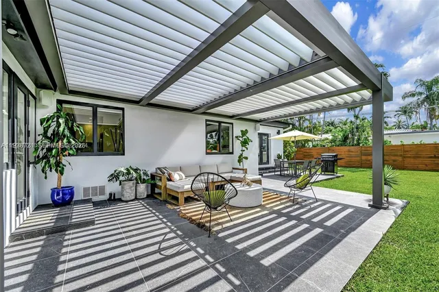 a view of a patio with chairs and potted plants