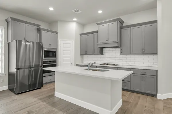 a kitchen with stainless steel appliances granite countertop a stove a refrigerator and a sink