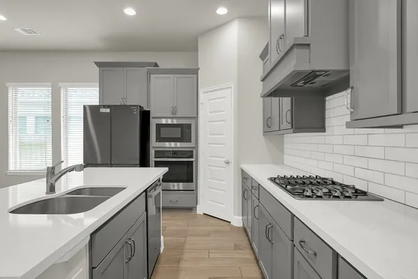 a kitchen with stainless steel appliances granite countertop a sink stove and refrigerator