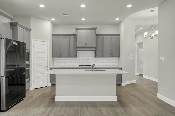 a kitchen with kitchen island a sink stainless steel appliances and cabinets
