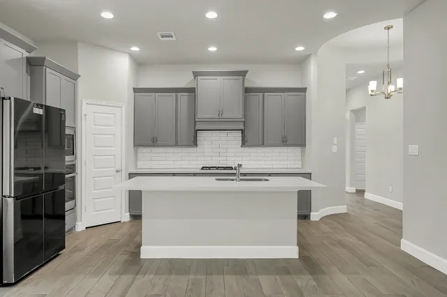 a kitchen with kitchen island a sink stainless steel appliances and cabinets