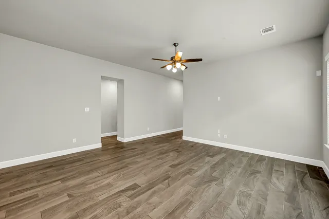 a view of an empty room with wooden floor