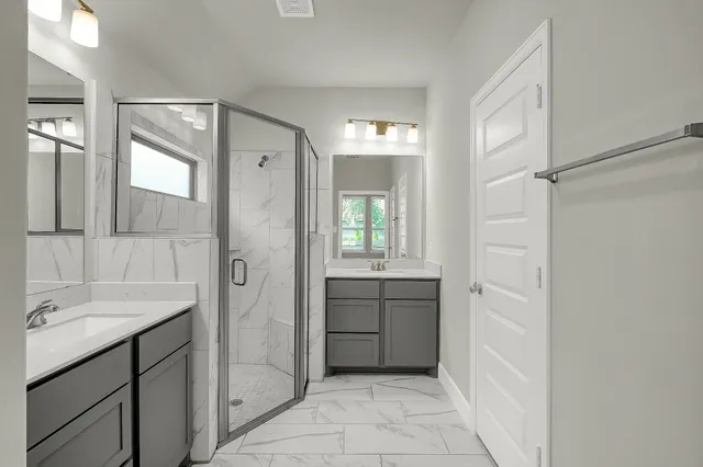a bathroom with a shower sink and mirror