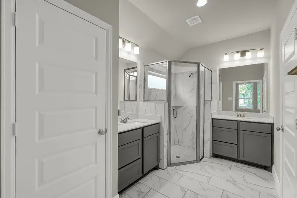 a spacious bathroom with a shower sink and mirror