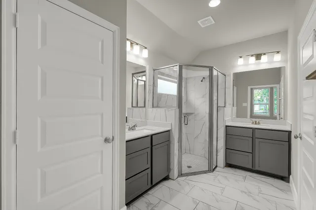 a spacious bathroom with a shower sink and mirror