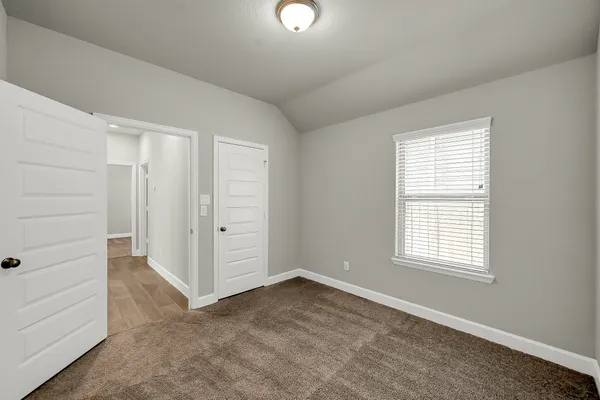 an empty room with windows and closet