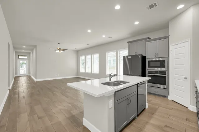 a kitchen with stainless steel appliances granite countertop a sink stove and refrigerator