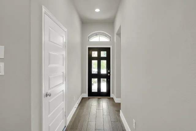a view of a hallway view with wooden floor and a window