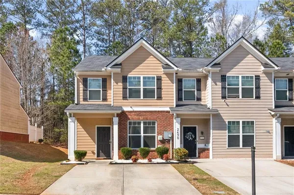 a front view of a house with yard and parking