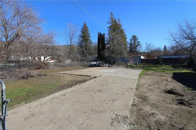 a view of a yard with trees on both side of house