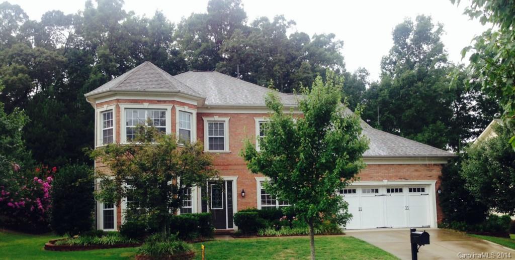 a front view of a house with a yard and trees