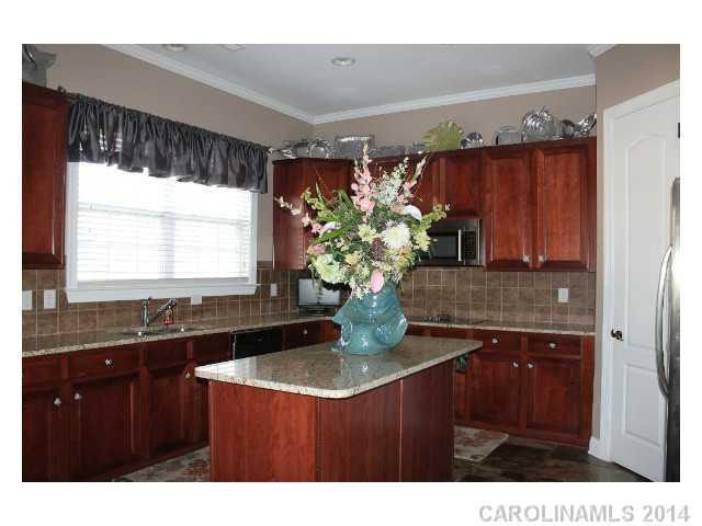 573 Quicksilver Trail Fort Mill, SC 29708 - Photo 7 of 16 a kitchen with kitchen island granite countertop a sink cabinets and a large window