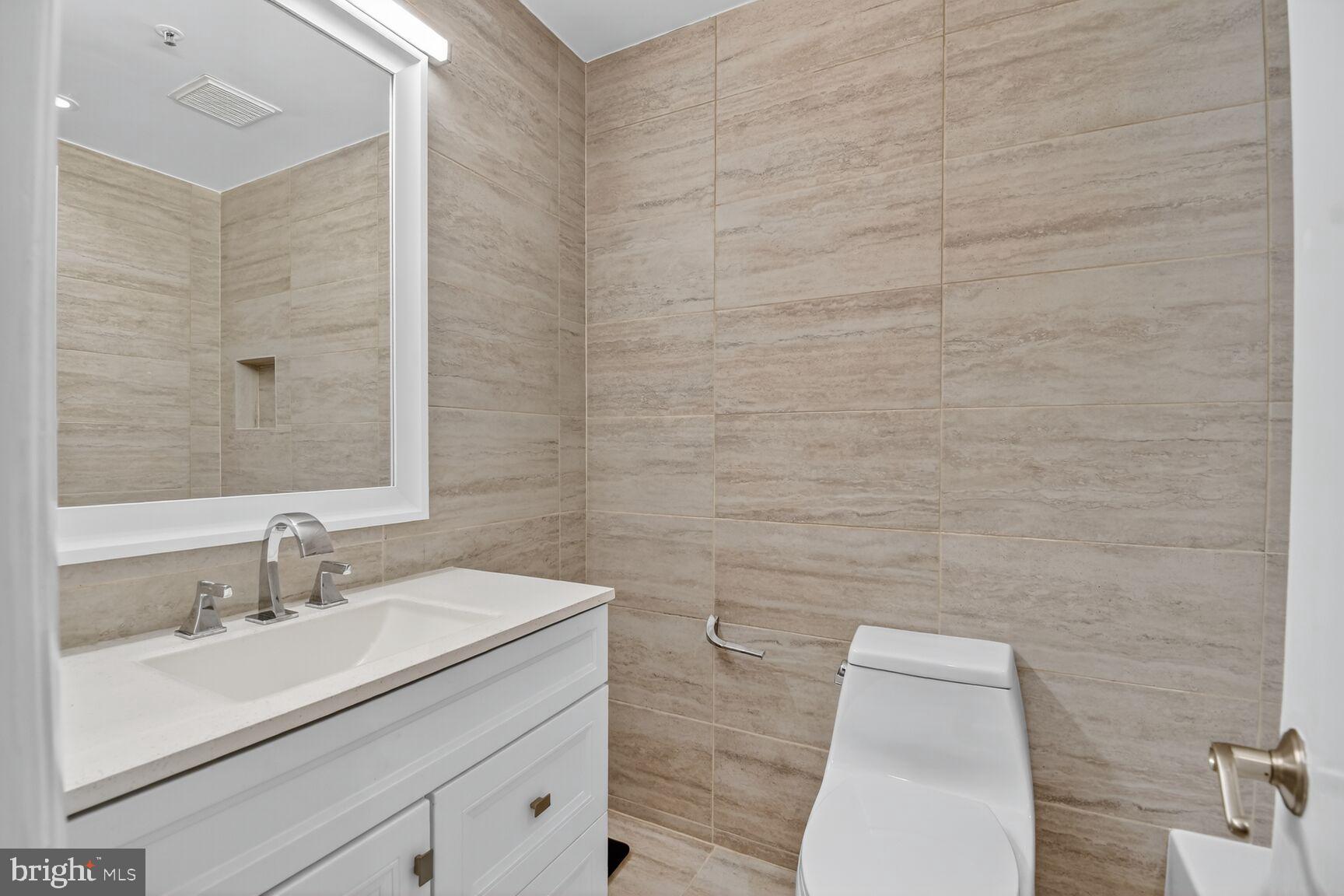 1001 North Vermont Street, Unit 102 Arlington, VA 22201 - Photo 12 of 27 a bathroom with a sink a toilet and mirror