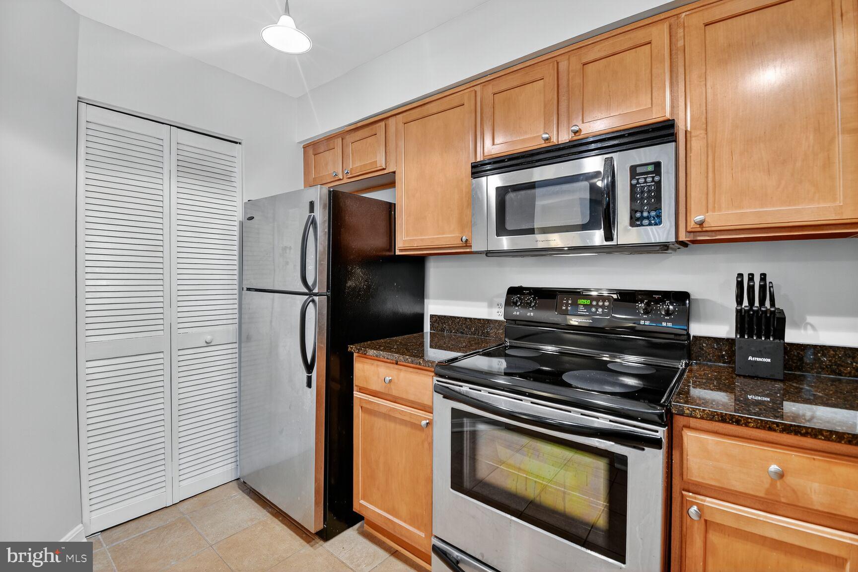 1001 North Vermont Street, Unit 102 Arlington, VA 22201 - Photo 7 of 27 a kitchen with stainless steel appliances granite countertop a stove microwave and refrigerator