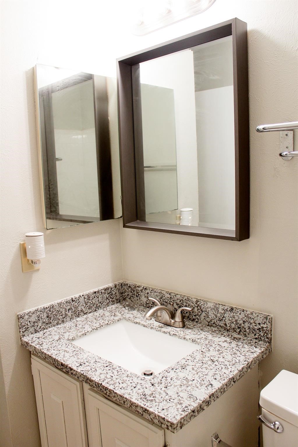39 South White Pebble Court Spring, TX 77380 - Photo 4 of 6 a bathroom with a granite countertop sink and a mirror