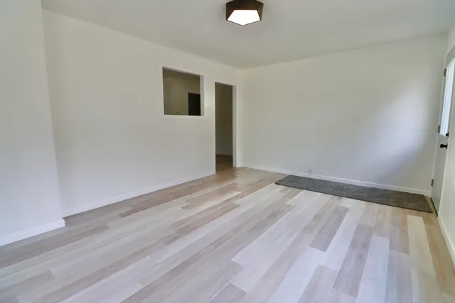 a view of a room with wooden floor and white walls