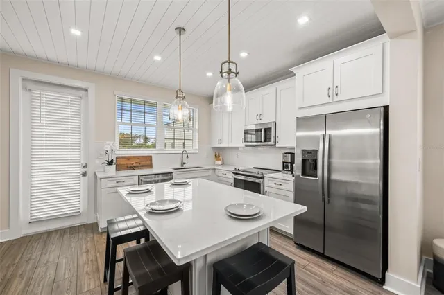 a kitchen with refrigerator cabinets dining table and chairs