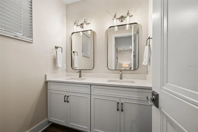 a bathroom with double vanity sinks and a mirror