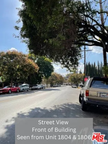 a view of car parked on the side of a street