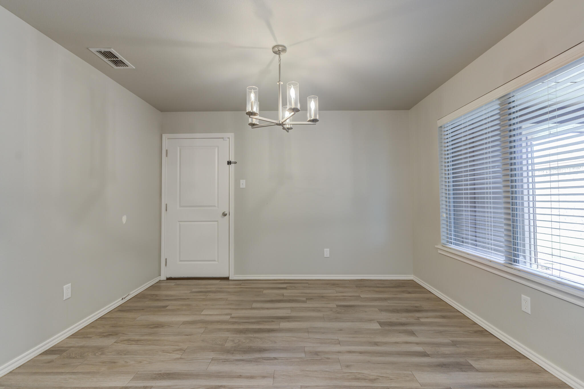 6902 67th Street Lubbock, TX 79424 - Photo 11 of 35 wooden floor in an empty room with a window