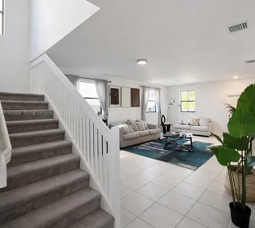 a living room with furniture and a potted plant