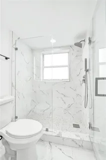 a white toilet sitting next to a bathroom sink