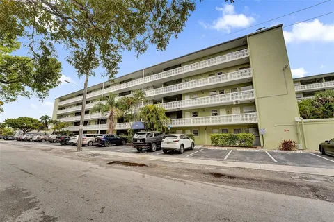 a view of building with cars parked in front of it