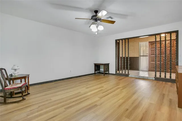 a view of an empty room with a window and wooden floor