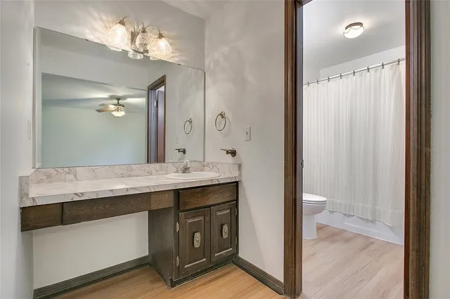 a bathroom with a granite countertop sink a mirror and a shower