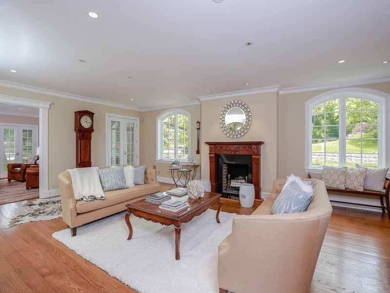 87 Goodwives River Road Darien, CT 06820 - Photo 6 of 31 a living room with furniture a fireplace and a table