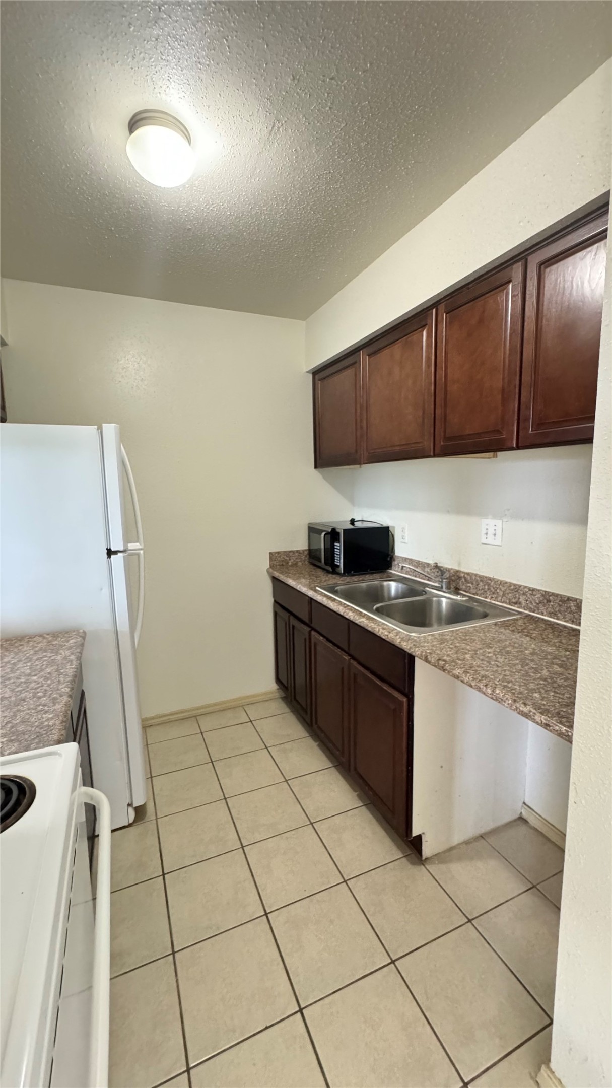 10802 Kingspoint Road Houston, TX 77075 - Photo 11 of 18 a kitchen with a sink a stove and a refrigerator