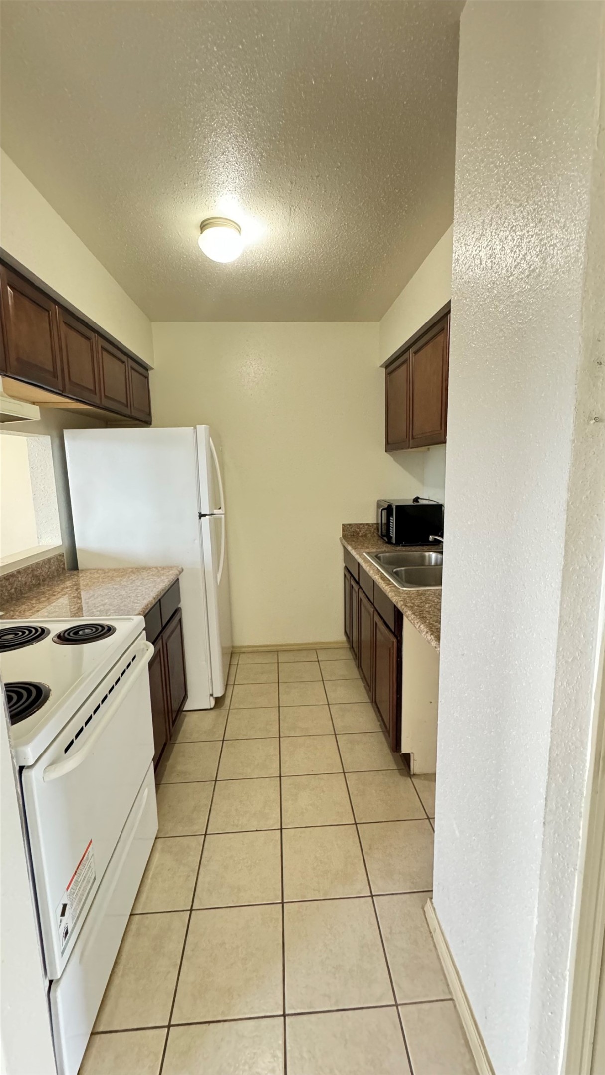 10802 Kingspoint Road Houston, TX 77075 - Photo 10 of 18 a kitchen with a stove and a microwave