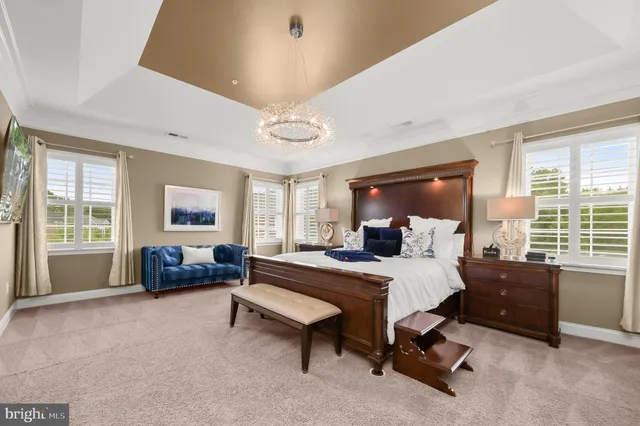 a large bedroom with a large bed and wooden floor