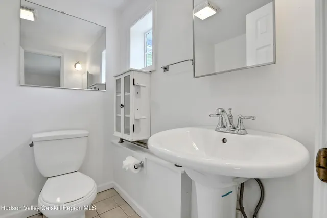 a bathroom with a sink a toilet and a mirror