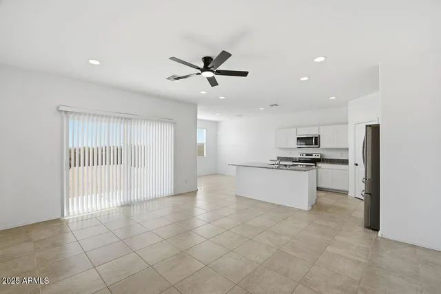 a large white kitchen with kitchen island a sink stainless steel appliances and cabinets