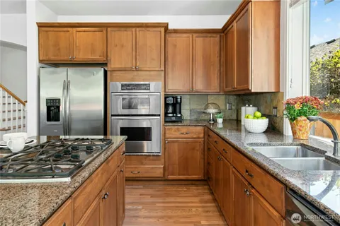 a kitchen with stainless steel appliances granite countertop a sink stove and refrigerator